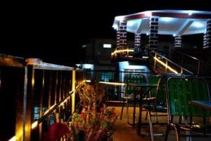 un balcon avec des chaises et des tables et des escaliers la nuit dans l'établissement DEE JAY RESORTS (A UNIT OF EATINOVA FOODSTAY HOSPITALITY PVT.LTD., à Dhaliara 10 autres photos