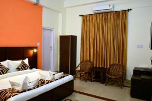 une chambre avec un lit, une table et des chaises dans l'établissement DEE JAY RESORTS (A UNIT OF EATINOVA FOODSTAY HOSPITALITY PVT.LTD., à Dhaliara