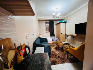 a living room with a couch and a bed at Cottage chill in Kampala