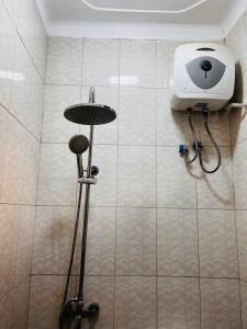 a bathroom with a blow dryer on the wall at Cottage chill in Kampala +19 photos