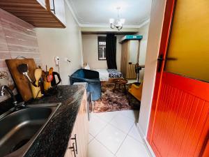 a kitchen with a sink and a room with a bed at Cottage chill in Kampala