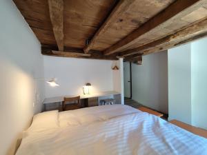 1 dormitorio con cama blanca y escritorio en Venta de Arrieta, en Saragüeta