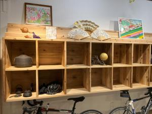 una libreria di legno con libri e una bicicletta di ゲストハウス 一番街ジャンクション a Fujiidera