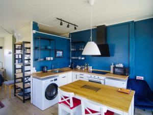 cocina con paredes azules, mesa y lavadora en Myvo The Studio apartment at Geiteyjarströnd 4, en Reykjahlíð