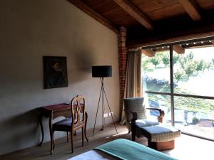 a bedroom with a desk and chairs and a window at MiaClara Relais in Alba