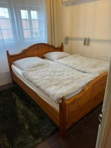 a wooden bed with two pillows on it in a bedroom at Zur Baumwolle in Nuremberg