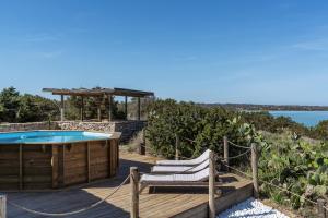 a deck with a hot tub and two chairs at Cas Saliners - Villa Can Paya in La Savina