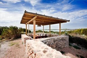 - un mur en pierre avec un pavillon au-dessus dans l'établissement Cas Saliners - Villa Can Paya, à La Savina