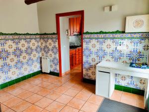 cocina con paredes de azulejos azules y blancos en Casa rural Cal Codina, en Els Prats de Rei