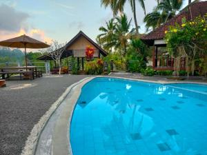 シデメンにあるVilla Joglo tepi sungaiの家の前の青いスイミングプール