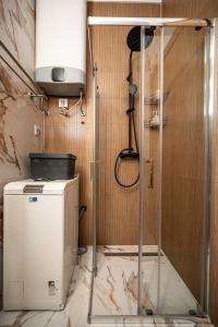 eine Dusche im Bad mit einer Duschkabine aus Glas in der Unterkunft TORRO LUX Apartment in Palić