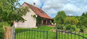 una casa vieja con una valla delante de ella en Domaine de la cure, en Curgy
