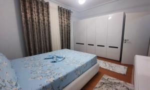 a bedroom with a blue bed and a door at Vila Seitaj in Sarandë