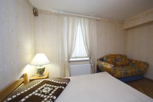 Un dormitorio con una cama y una silla y una ventana. en Žubītes 8, en Jūrmala