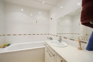 Un baño blanco con bañera y lavabo. en Žubītes 8, en Jūrmala 9 fotos más
