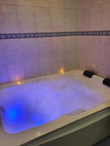 a bath tub filled with blue water in a bathroom at Eco Pousada Eldorado Lumiar in Lumiar +34 photos