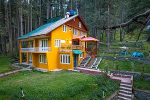 a small yellow house with a metal roof at Hotel Little Silver in Pahalgām