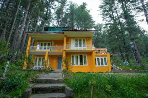 a yellow house in the middle of a forest at Hotel Little Silver in Pahalgām