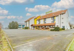 an empty parking lot in front of a hotel at B&B HOTEL Poitiers 3 Futuroscope in Chasseneuil-du-Poitou