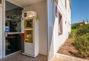 uma máquina de multibanco do lado de fora de um edifício em B&B HOTEL Béziers em Béziers