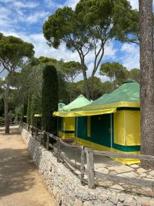 een geel en groen gebouw met bomen op de achtergrond bij Càmping Castell Montgrí **** in L'Estartit