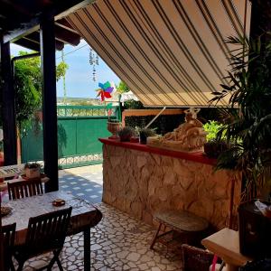 eine Terrasse mit einem Tisch, Stühlen und einer Steinmauer in der Unterkunft Salento - A Casa di Lilli in Porto Cesareo