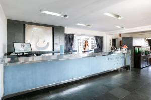 a woman sitting at a counter in a restaurant at Hotel LIVVO Risco del Gato Suites in Costa Calma