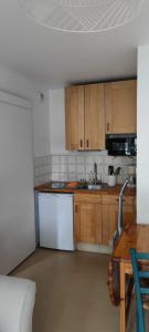 una cocina con electrodomésticos blancos y armarios de madera en Cabourg Plage, en Cabourg