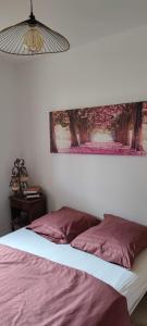ein Schlafzimmer mit einem Bett und einem Bild an der Wand in der Unterkunft Cabourg Plage in Cabourg