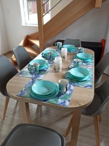 a wooden table with blue plates and cups on it at Bałtyckie domki Kopalino in Kopalino +19 photos