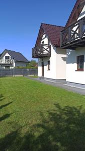 a house with a green lawn in front of it at Bałtyckie domki Kopalino in Kopalino