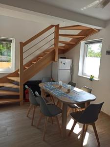 a dining room with a table and chairs and a staircase at Bałtyckie domki Kopalino in Kopalino