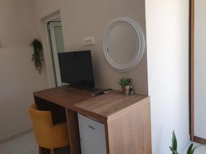 a room with a desk with a television and a mirror at Gusto di Casa Rooms in Ksamil