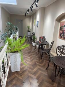 een wachtruimte met tafels, stoelen en planten bij Perla De Mar Hotel in Baku
