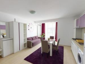 uma cozinha e sala de estar com mesa e cadeiras em Papaya Apartment on the Seafront em Mamaia Nord – Năvodari