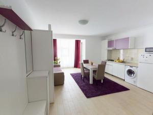 uma cozinha branca com uma mesa e uma sala de jantar em Papaya Apartment on the Seafront em Mamaia Nord – Năvodari