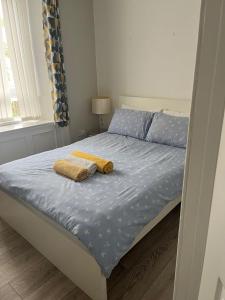 een bed met twee handdoeken in een slaapkamer bij Largs Apartment, Spacious & Modern 1 Bed near beach & shops in Largs