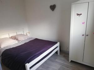 ein Schlafzimmer mit einem Bett und einem weißen Schrank in der Unterkunft Maison entre lac et océan WIFI in Lacanau