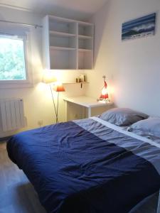 een slaapkamer met een bed, een bureau en een raam bij Maison entre lac et océan WIFI in Lacanau
