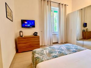 a bedroom with a bed and a tv on the wall at DMC Residence - Alloggi Turistici in Anzio
