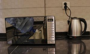 a toaster oven on a counter with a coffee pot at Zen Haven by StayMehman in Rawalpindi