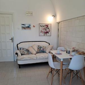 sala de estar con sofá y mesa en Trulli di Rosa en Locorotondo