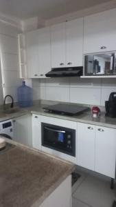 納塔爾的住宿－Apartamento inteiro litoral norte Natal RN，厨房配有白色橱柜和微波炉