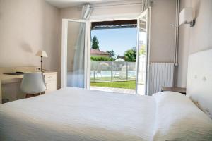 a bedroom with a bed and a sliding glass door at le Relais des Tuileries in Séreilhac