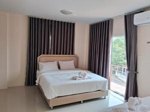 um quarto com uma cama com um bicho de peluche em เคทู เกสเฮาส์ (K2 Guesthouse) em Chon Buri