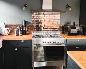 a kitchen with a stove and a brick wall at Villa Andernos les Bains in Andernos-les-Bains