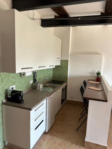 a kitchen with white cabinets and a table with chairs at Il Giardino Segreto in Cantalupo in Sabina +4 photos