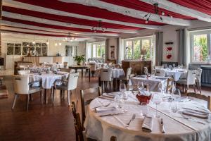 a dining room with tables and chairs with white tablecloths at le Relais des Tuileries in Séreilhac
