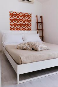 1 cama en un dormitorio con marco de cama blanco en Villa Chiara Porto Recanati, en Porto Recanati