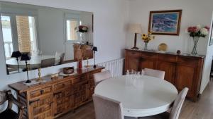 a dining room with a white table and chairs at Playa de Comillas in Comillas